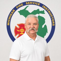 Portrait of a man with a white polo shirt standing in front of the Michigan Fire Service Instructors emblem.