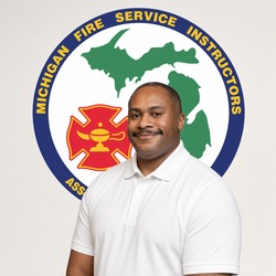Portrait of a man in a white polo shirt smiling, standing in front of the Michigan Fire Service Instructors Association emblem.
